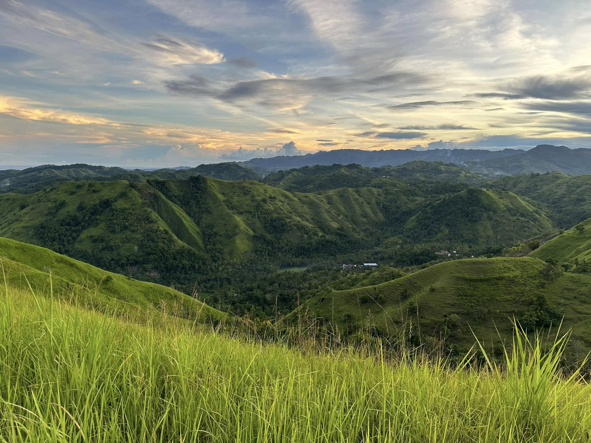 Lush undulating hills and valleys under clear blue skies in Candijay